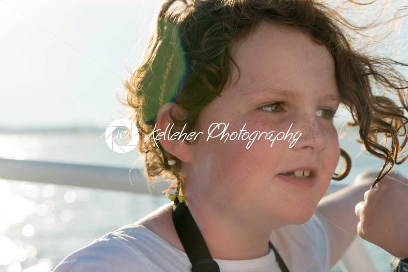Beautiful young girl on boat at sunset with sun flare behind her - Kelleher Photography Store