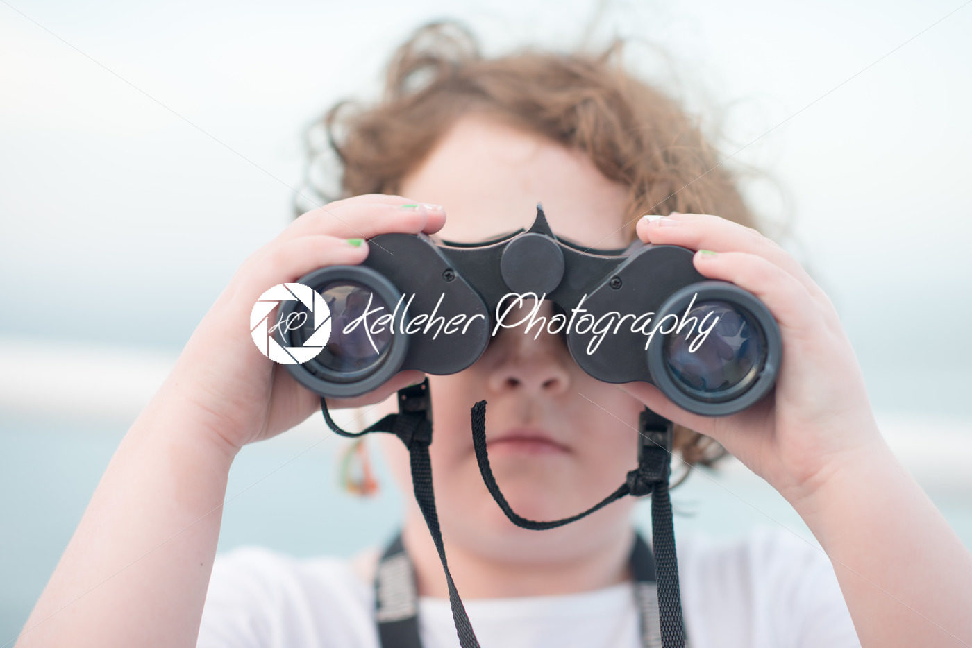 Beautiful young girl on boat looking directly at camera through binoculars - Kelleher Photography Store