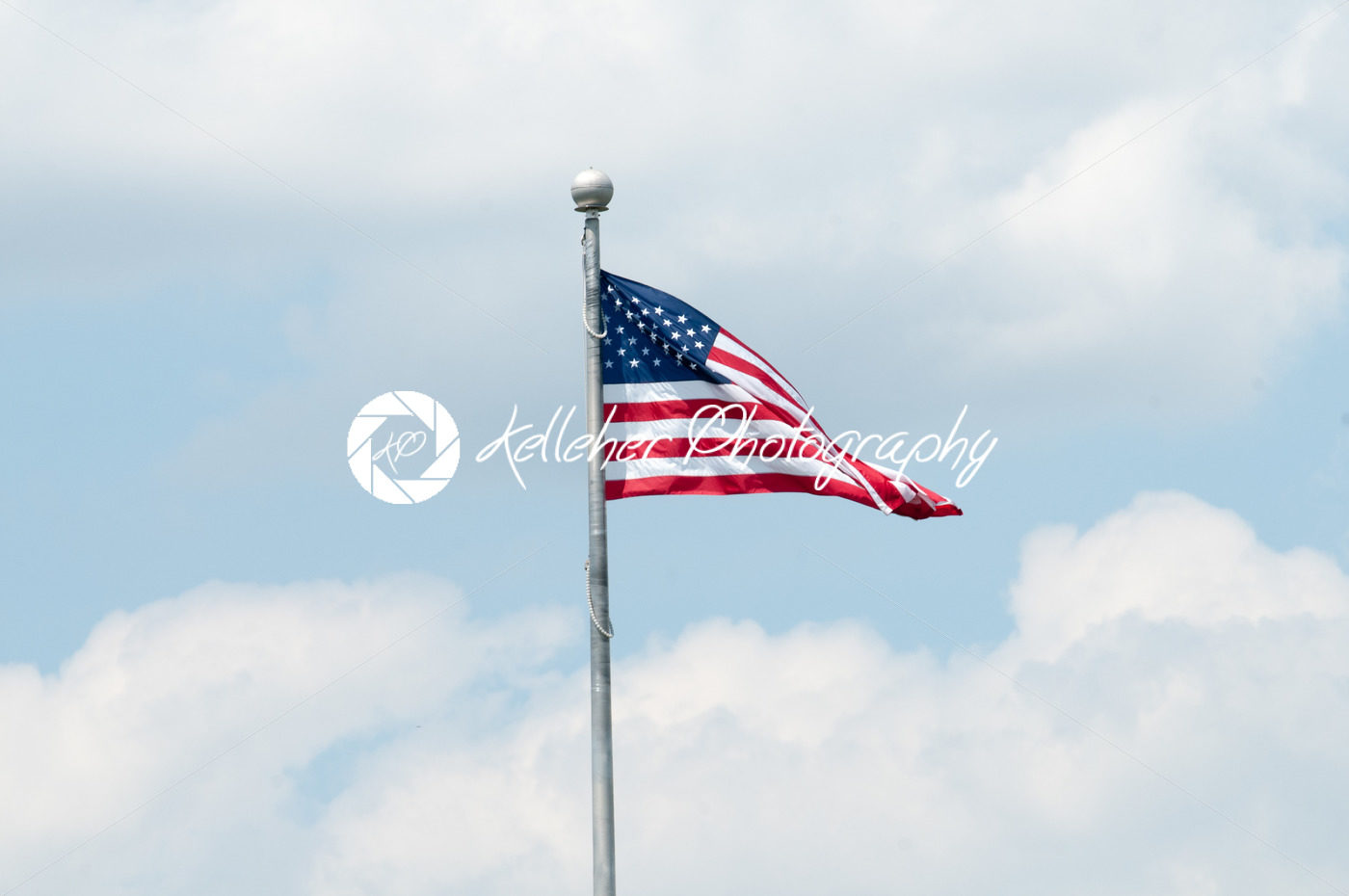 Flag of the United States of America with blue sky and clouds behind it - Kelleher Photography Store