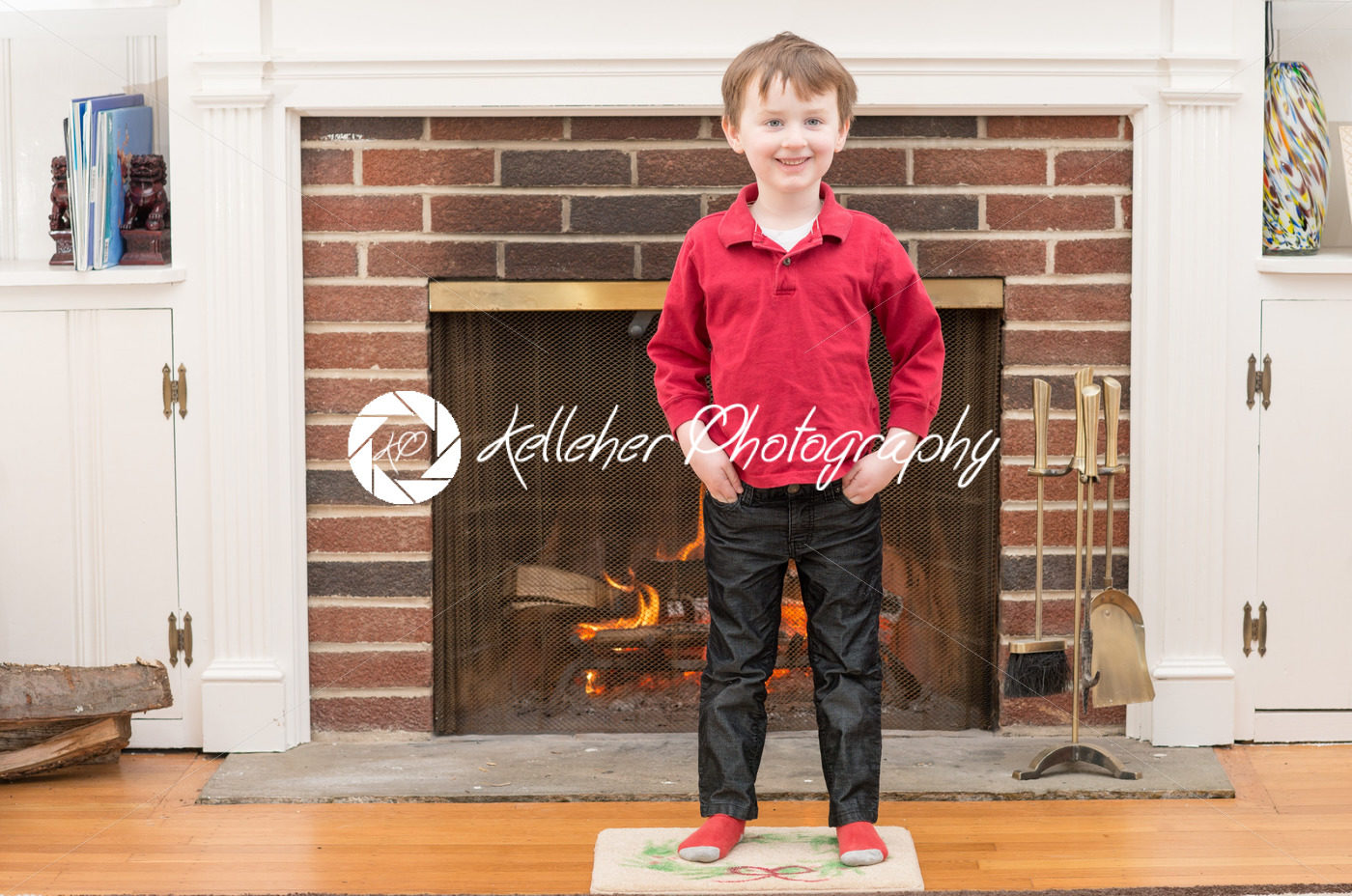 Portrait of a young smiling boy in front of a fireplace dressed for valentine’s day - Kelleher Photography Store