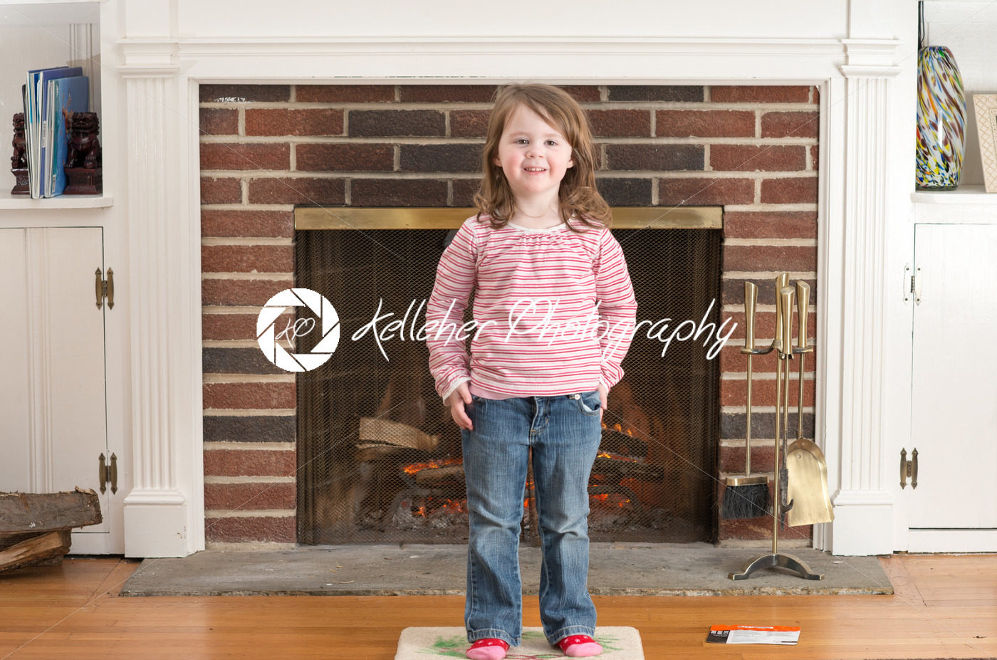 Portrait of a young smiling girl in front of a fireplace dressed for valentine’s day - Kelleher Photography Store