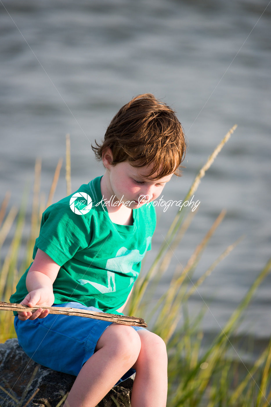 Young boy holding stick from among the reeds along the bay - Kelleher Photography Store