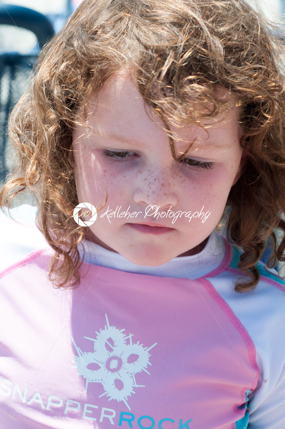 Young cute little girl playing at the seaside running into the surf on a sandy beach in summer sunshine - Kelleher Photography Store