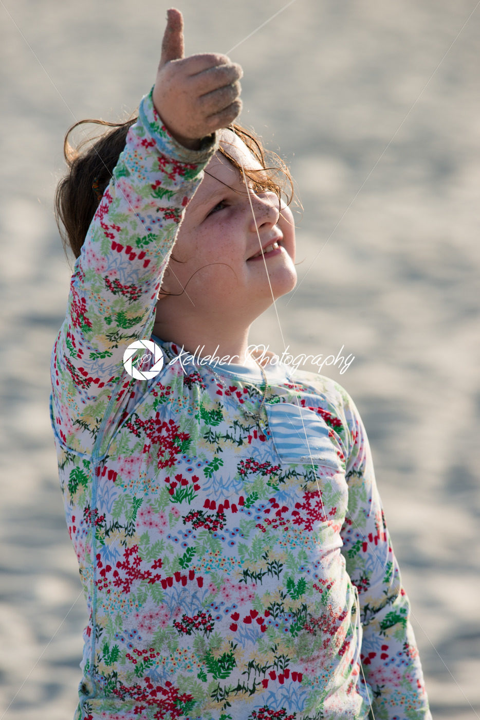Young girl on beach with kite smiling - Kelleher Photography Store