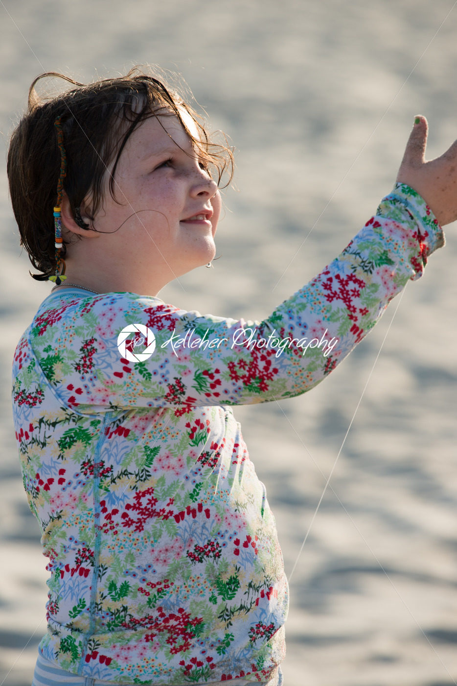 Young girl on beach with kite smiling - Kelleher Photography Store