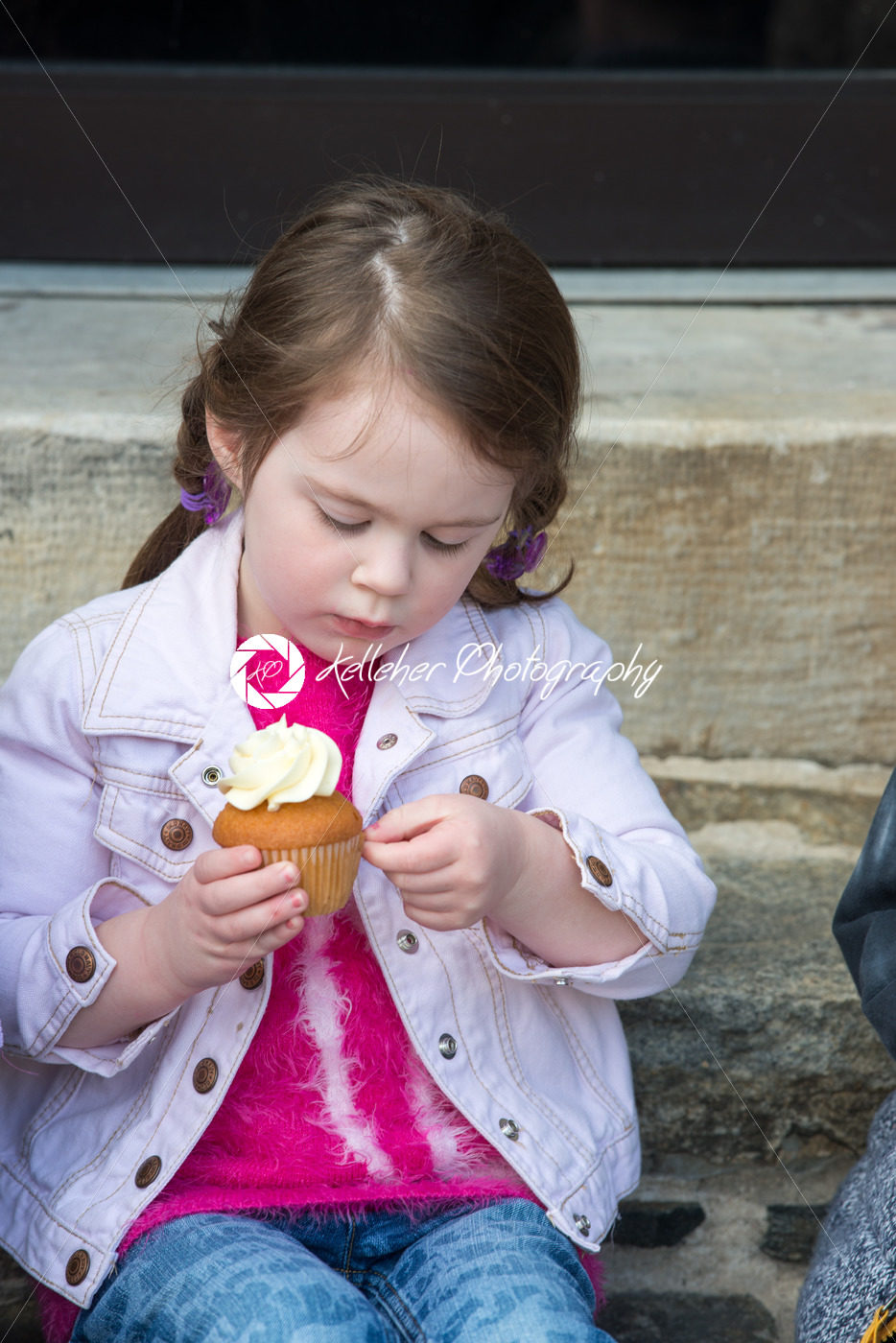 Young girl sitting outside eating a cupcake - Kelleher Photography Store