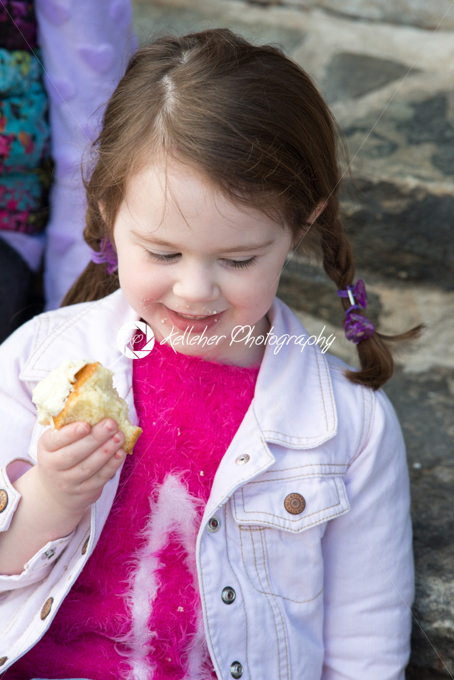 Young girl sitting outside eating a cupcake - Kelleher Photography Store