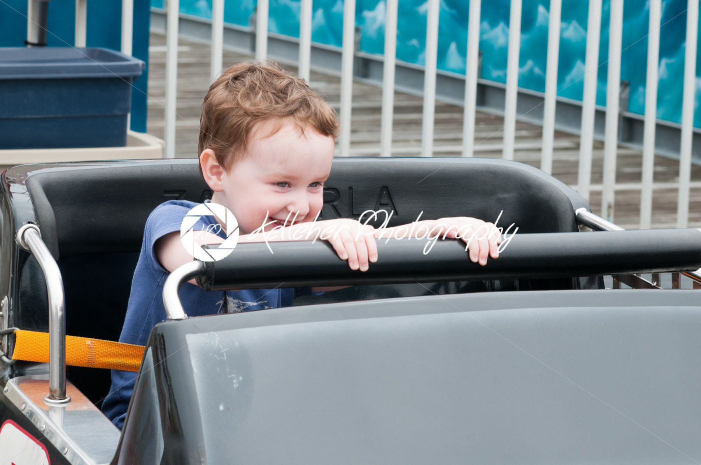 Young toddler boy having fun on boardwalk amusement ride - Kelleher Photography Store