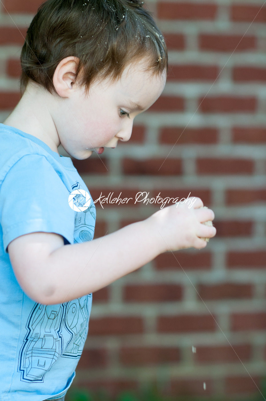Young toddler boy in front of red birck wall - Kelleher Photography Store