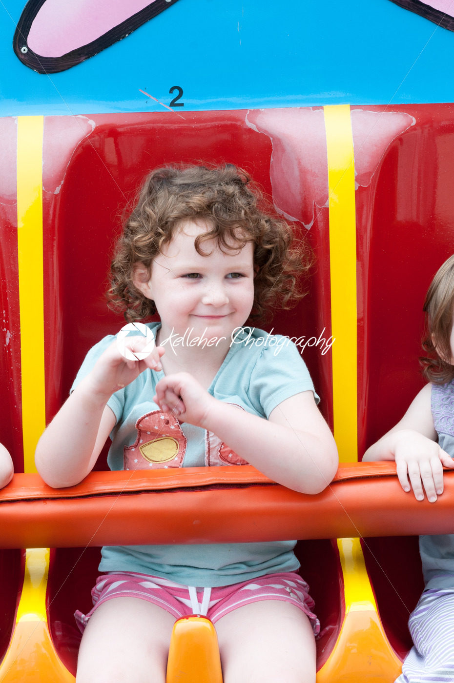 Young toddler girl having fun on boardwalk amusement ride - Kelleher Photography Store