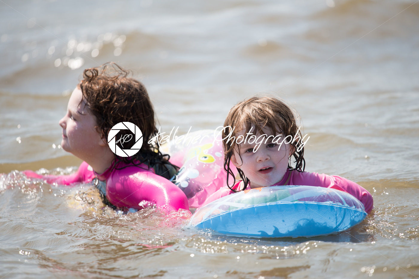 two young girls floating in inner tubes in a blissful state - Kelleher Photography Store