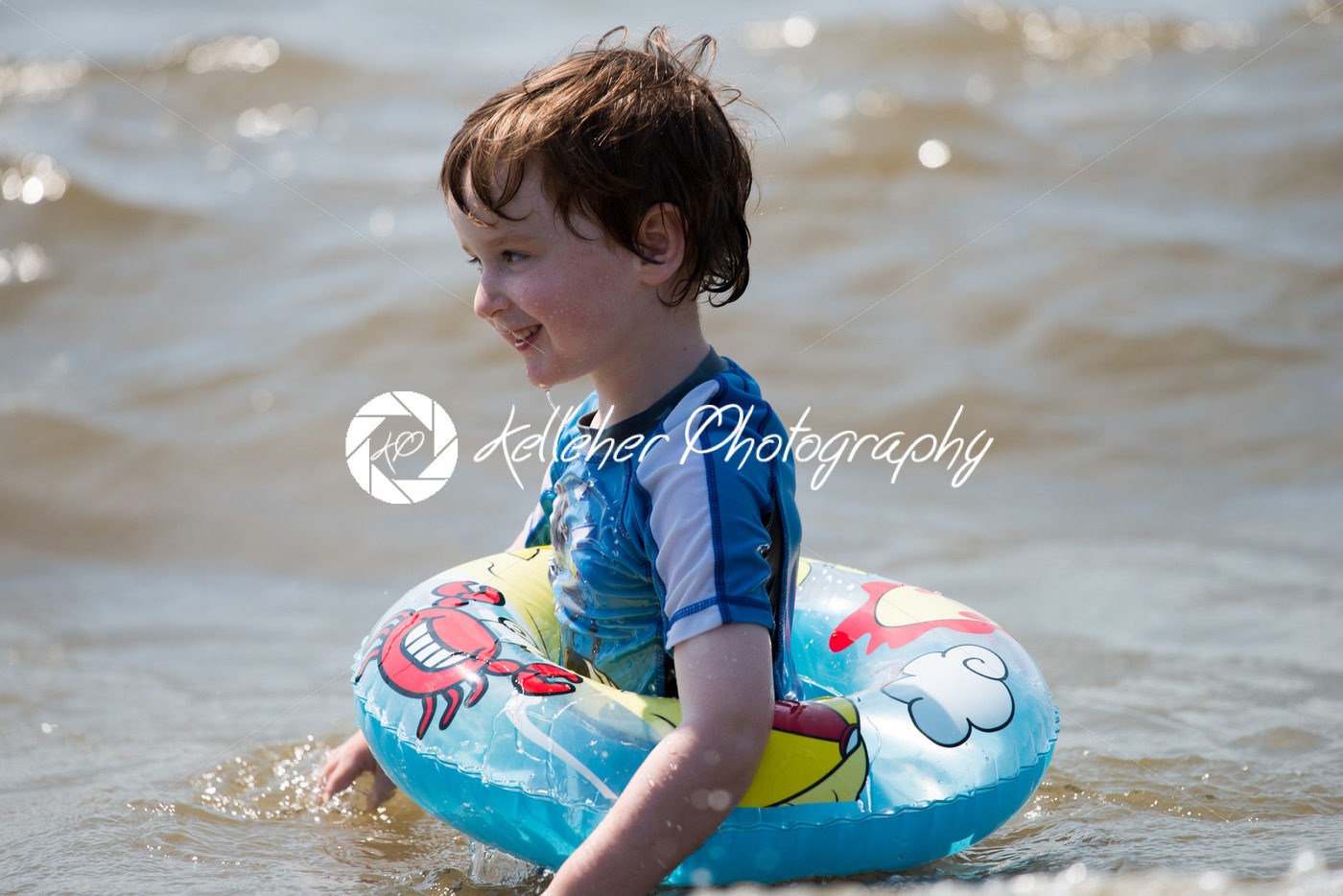 young boy floating in inner tubes in a blissful state - Kelleher Photography Store