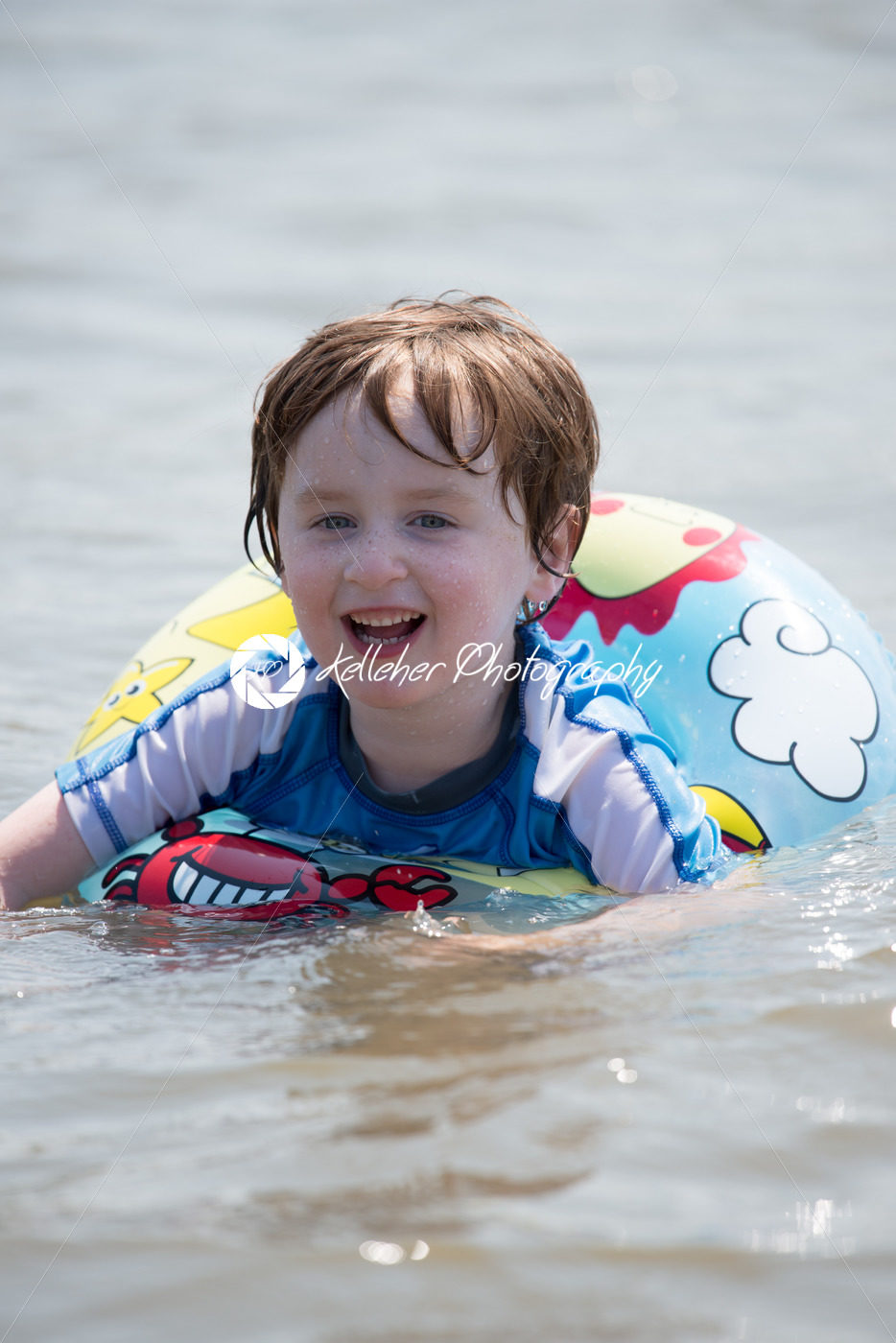 young boy floating in inner tubes in a blissful state - Kelleher Photography Store