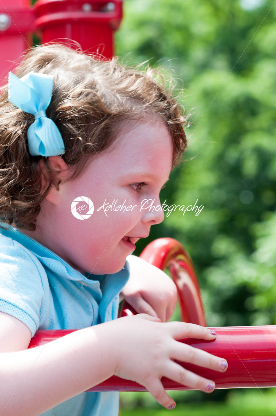 Young girl having fun outside at park on a playground swing set - Kelleher Photography Store