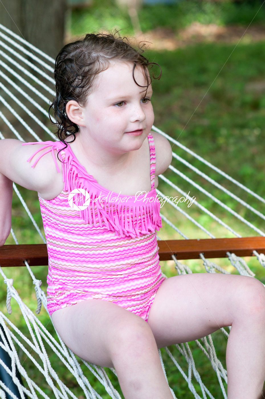 Young girl outside in swimming suit sitting on hammock - Kelleher Photography Store