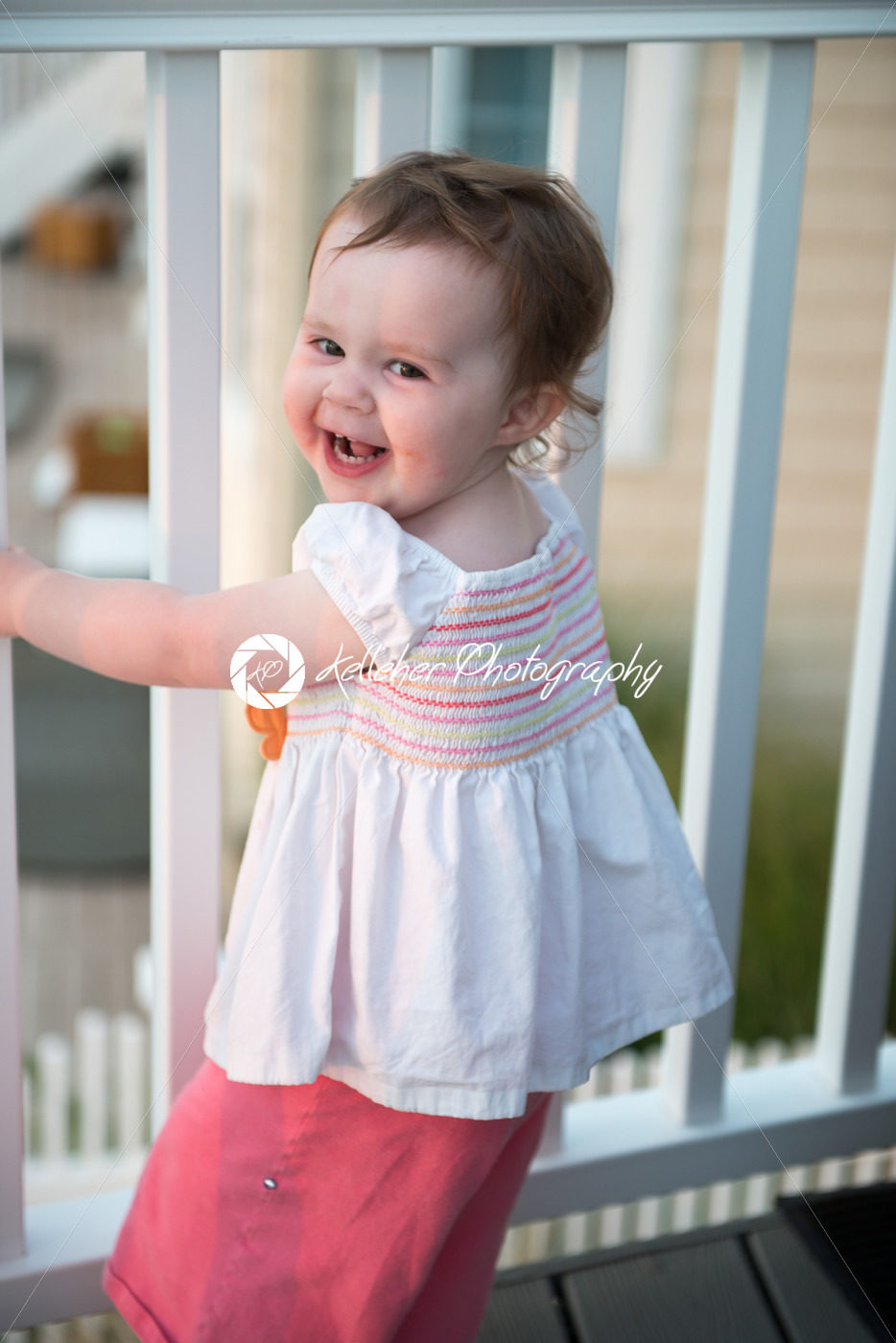 Young toddler girl on patio deck outside at sunset down at shore - Kelleher Photography Store