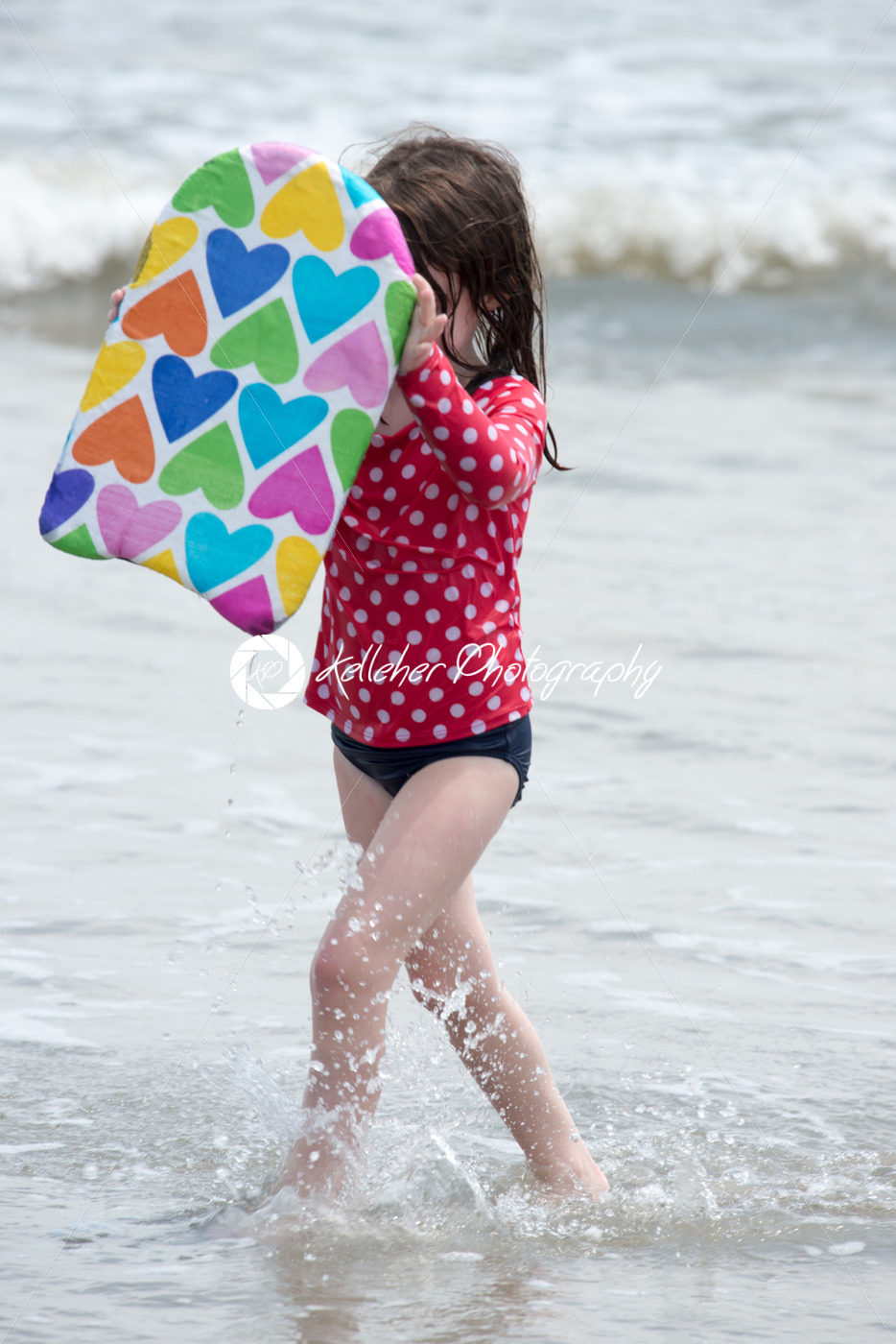 Girl coming out of the ocean waves with a boogy board - Kelleher Photography Store