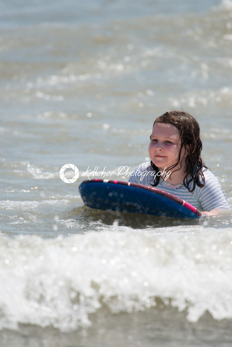 Girl surfing the waves in the ocean on a boogy board - Kelleher Photography Store
