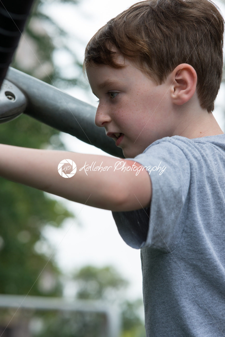 Young boy having fun outside at park on a playground climbing set - Kelleher Photography Store