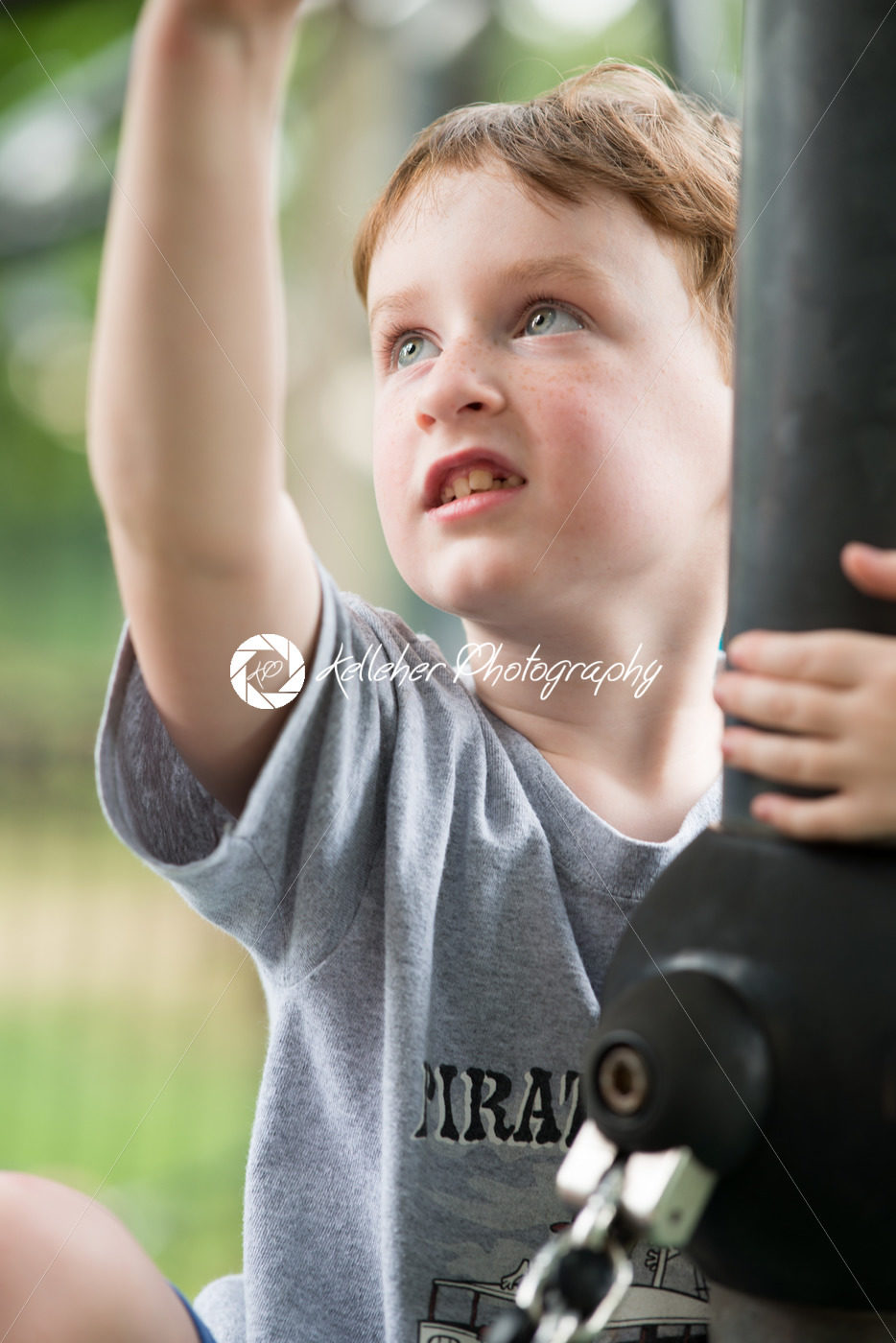 Young boy having fun outside at park on a playground climbing set - Kelleher Photography Store