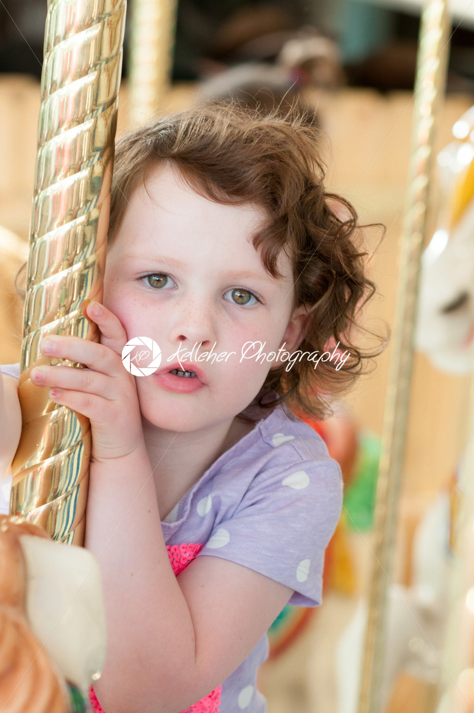 Young girl riding on fairground horse on carousel amusement ride at fairgrounds park outdoor - Kelleher Photography Store