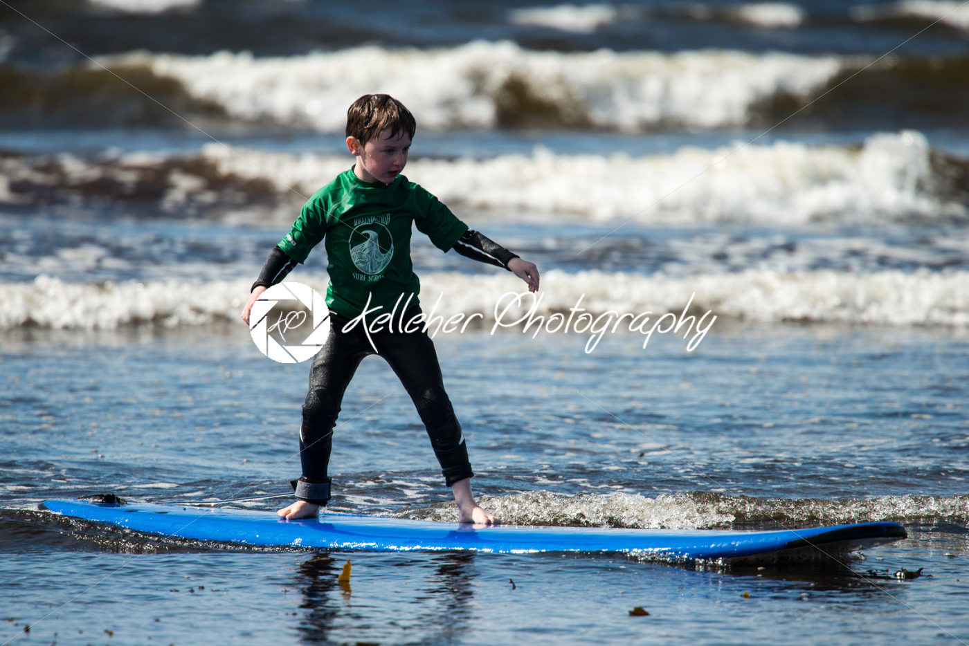 Young little boy on beach taking surfing lessons - Kelleher Photography Store