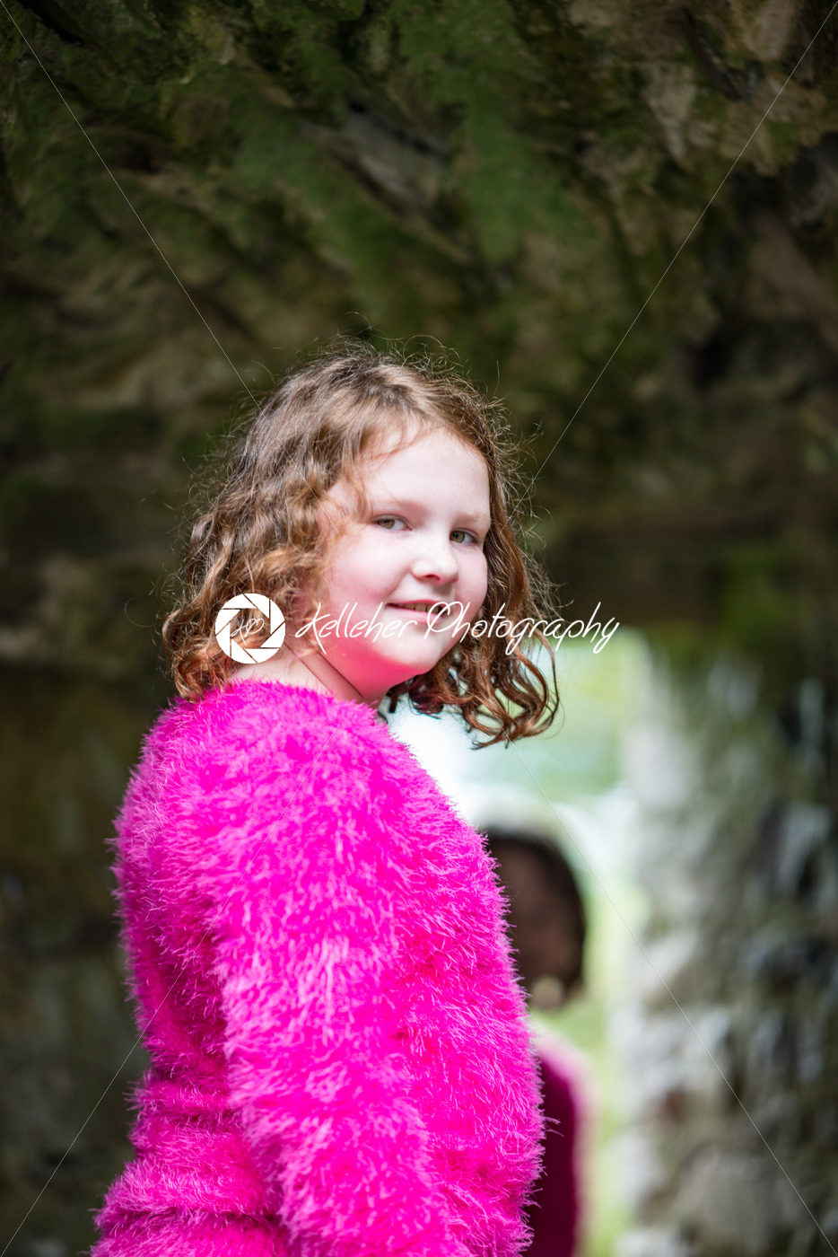 Young little girl portrait looking and smiling at the camera while exploring in an old castle - Kelleher Photography Store