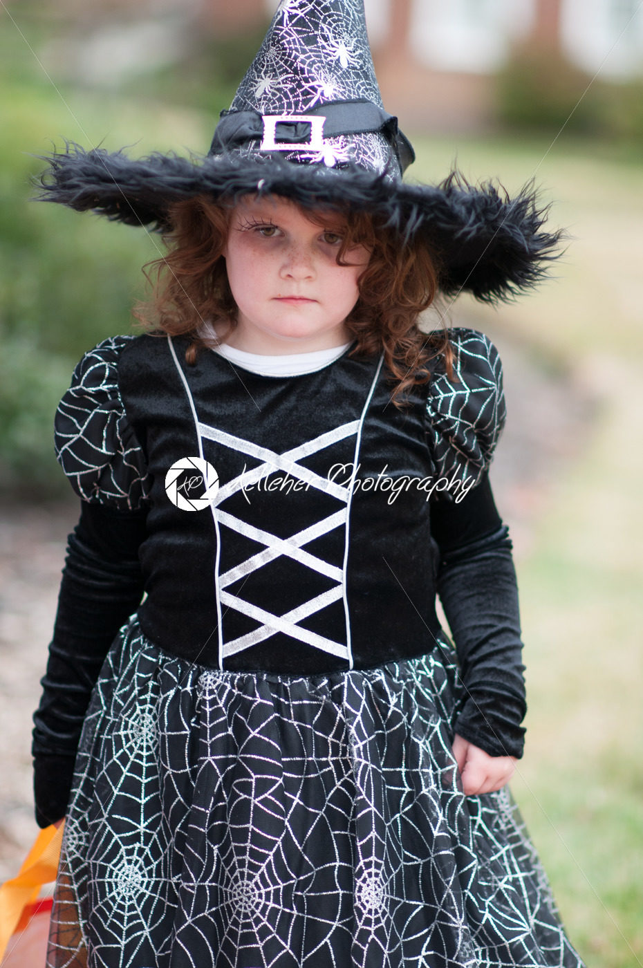 Little girl in witch costume having fun at Halloween trick or treat - Kelleher Photography Store