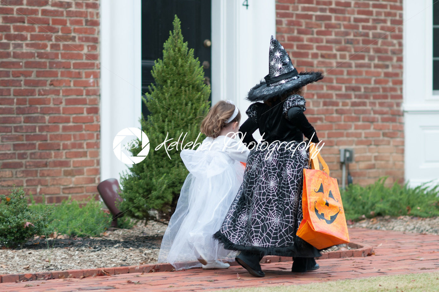 Little girls in witch and ghost costume having fun at Halloween trick or treat - Kelleher Photography Store