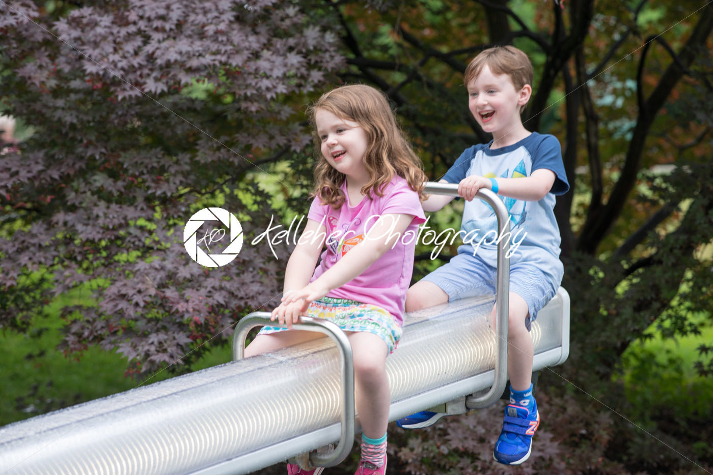 Two cute pre-school children sitting on a seesaw - Kelleher Photography Store
