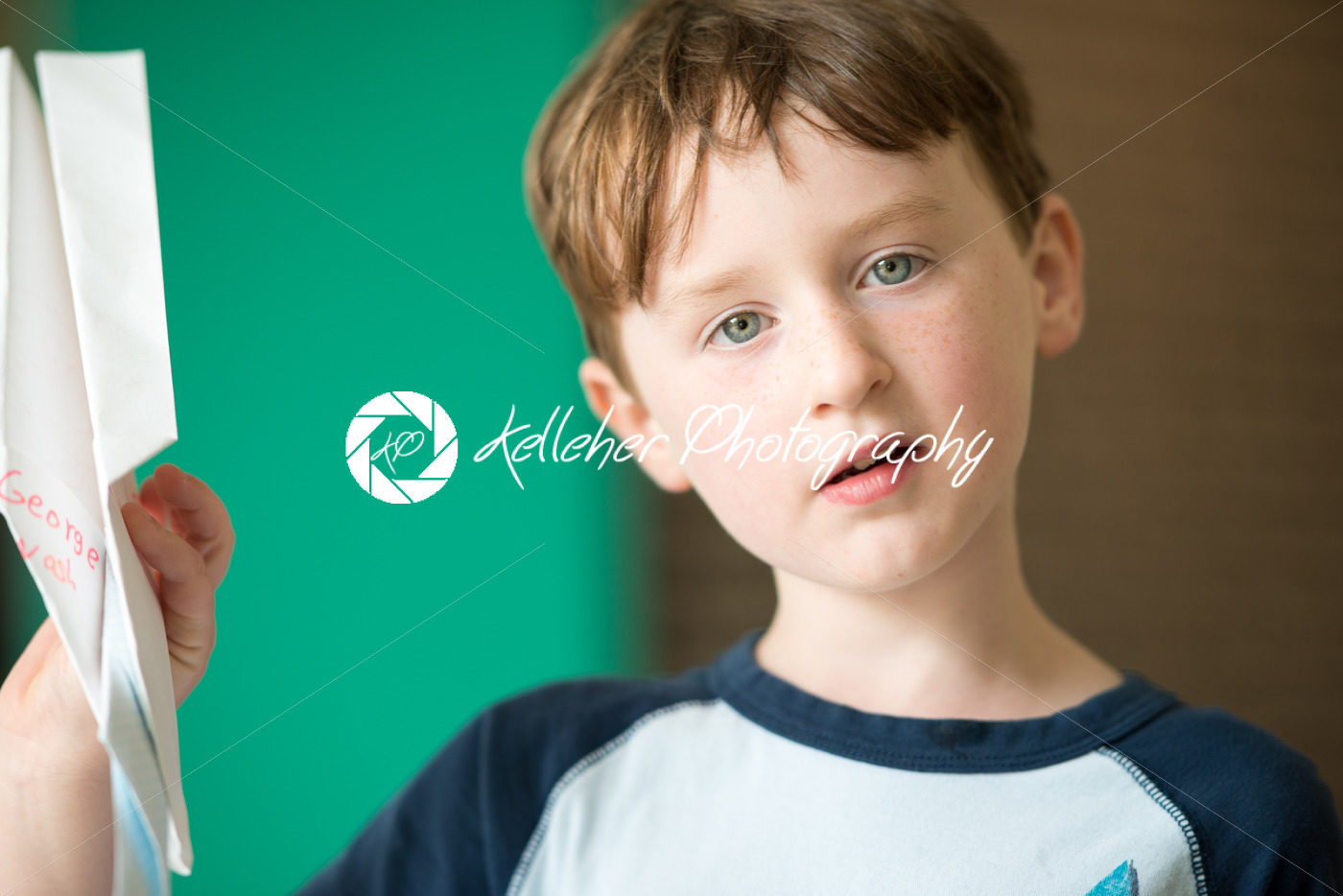 Young boy holding paper plane - Kelleher Photography Store