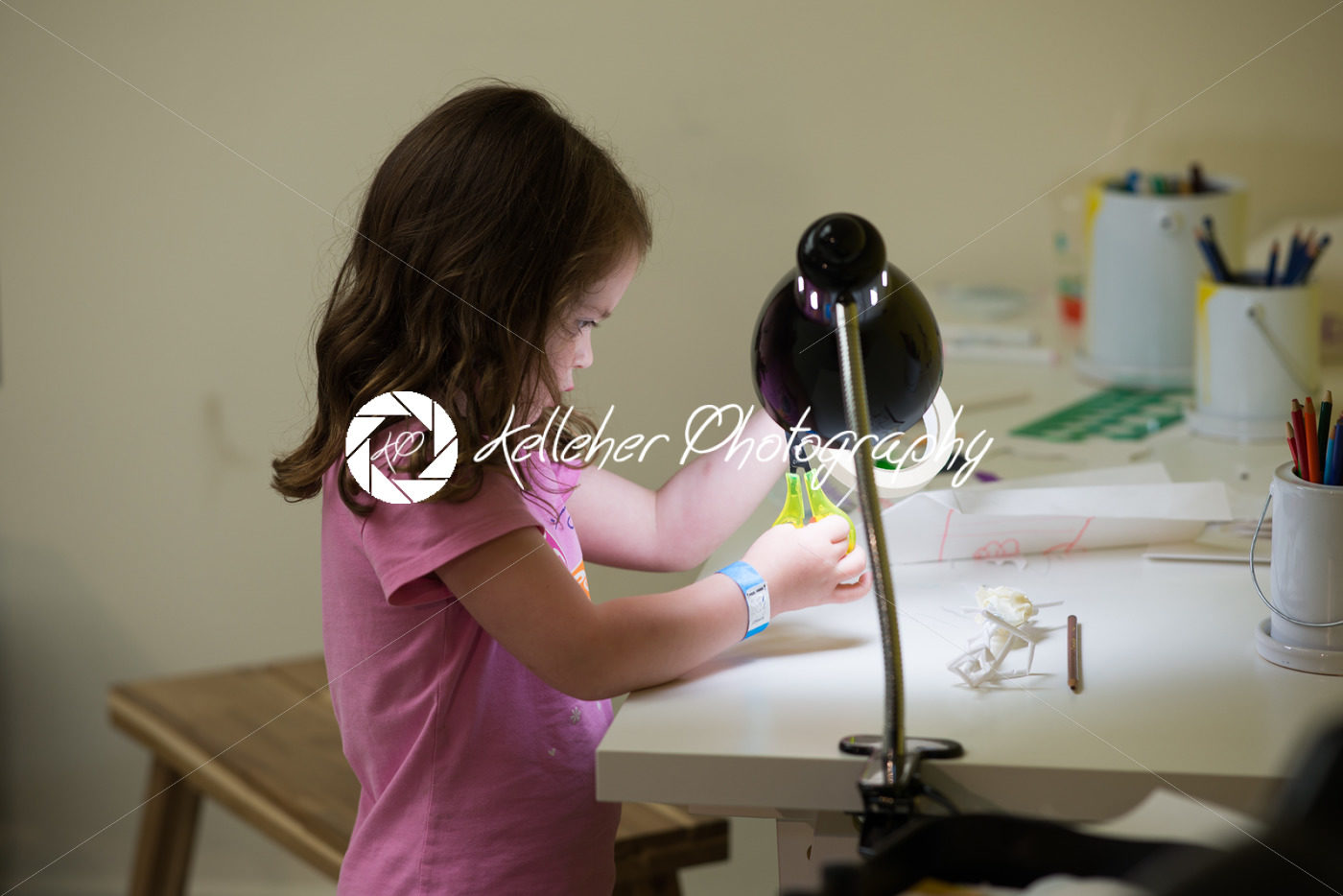 Young girl cutting tape at desk - Kelleher Photography Store