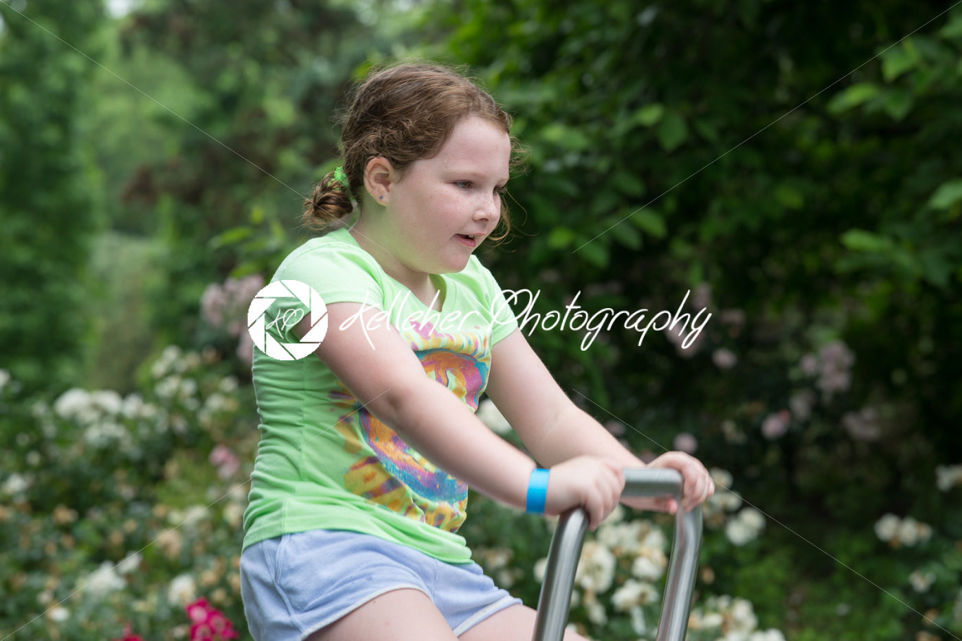 Young girl sat on ride in park - Kelleher Photography Store