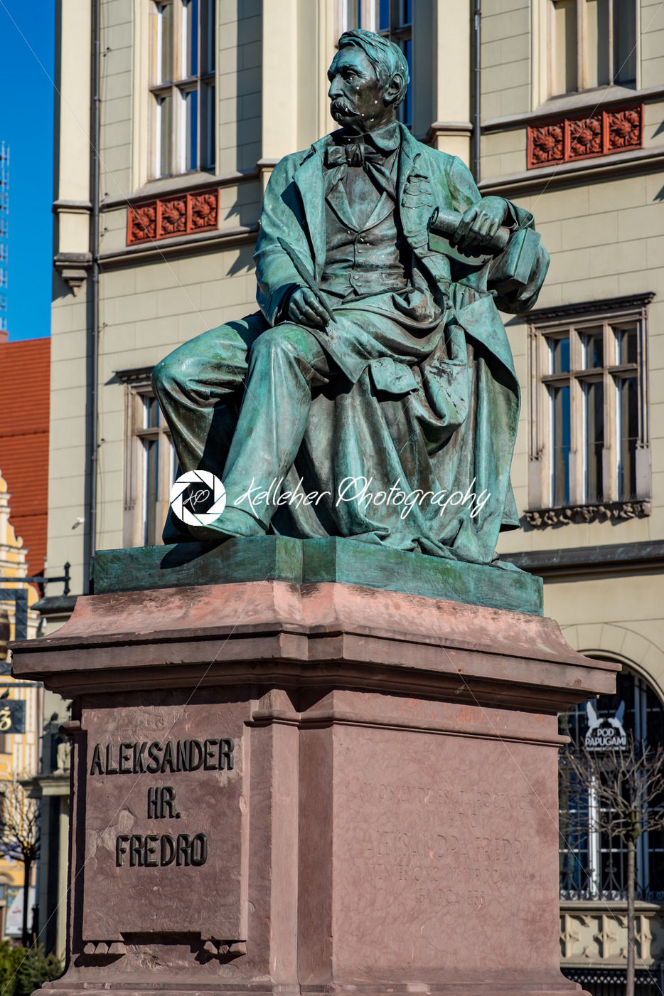 Wroclaw, Poland – March 9, 2018: Neoclassical bronze statue of famous Polish writer Alexander Fredro, 1897, by Leonard Marconi in warm sunlight , Market Square - Kelleher Photography Store