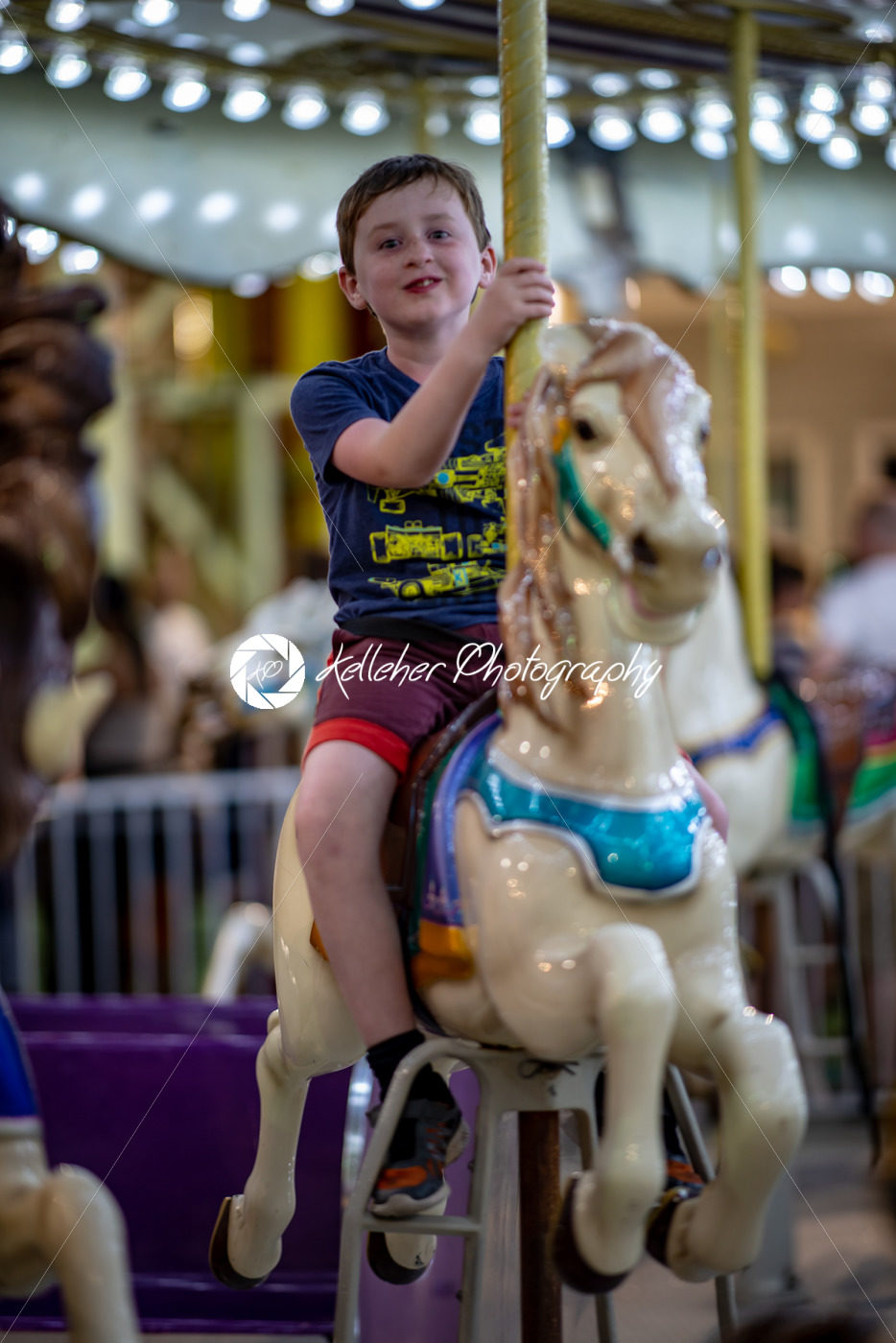 Happy young boy having fun on boardwalk amusement ride - Kelleher Photography Store