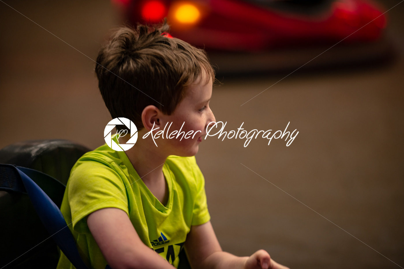 Happy young boy rides electric bumper car amusement ride on shore boardwalk - Kelleher Photography Store