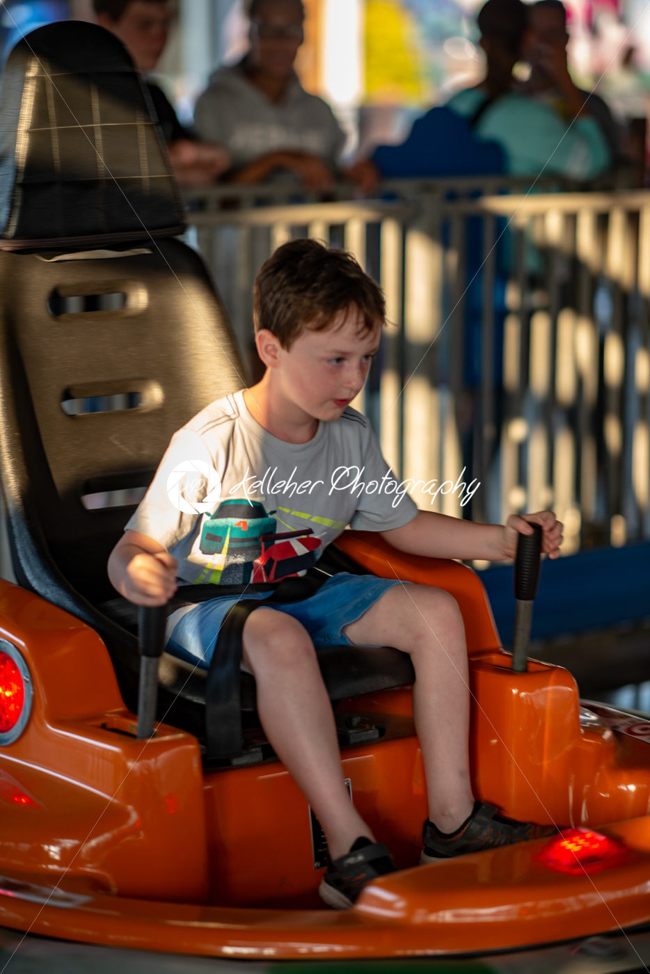Happy young boy rides electric bumper car amusement ride on shore boardwalk - Kelleher Photography Store