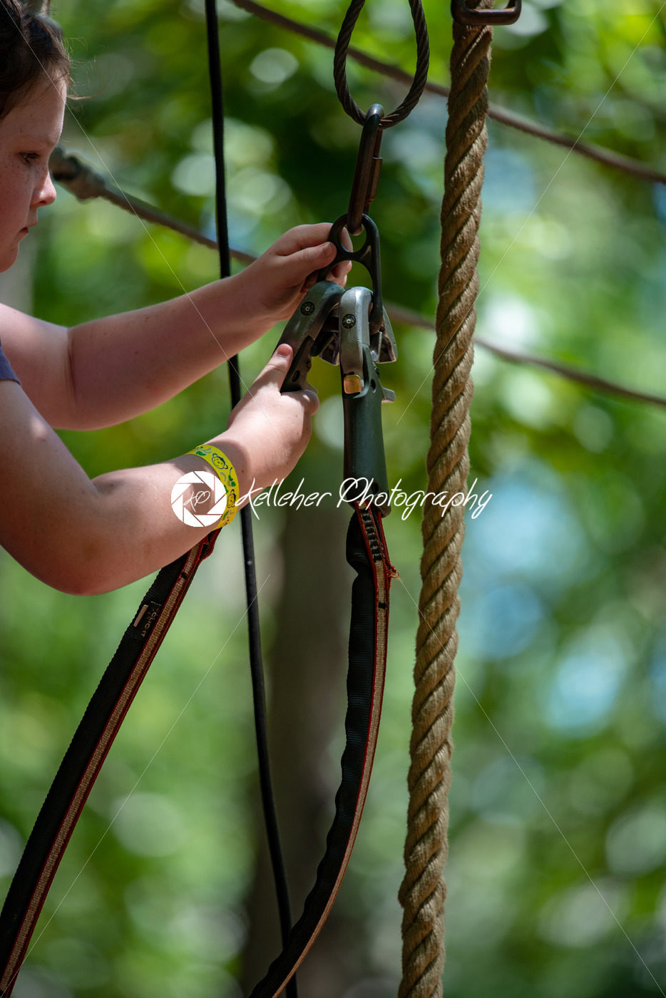 Portrait of a beautiful girl on a rope park among trees. Children summer activities. - Kelleher Photography Store
