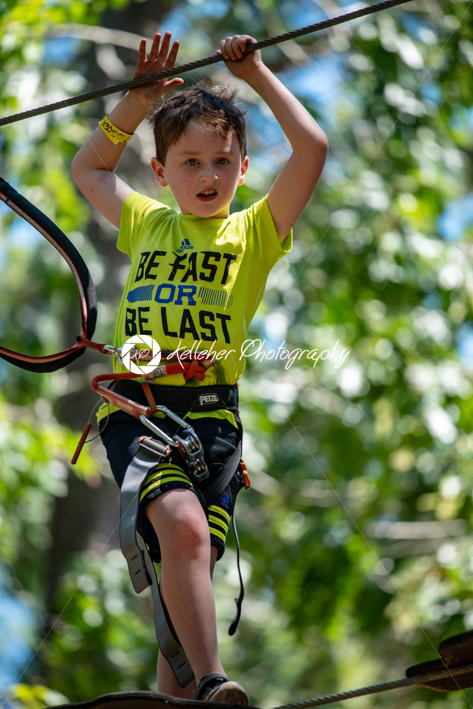 Portrait of a handsome boy on a rope park among trees. Children summer activities. - Kelleher Photography Store