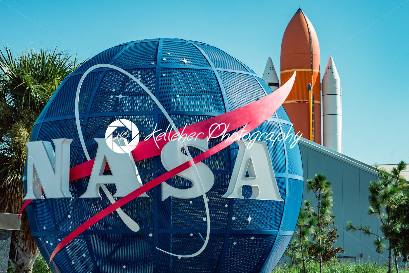 Cape Canaveral, Florida – August 13, 2018: NASA globe with space shuttle booster rocket in backgrond at NASA Kennedy Space Center - Kelleher Photography Store